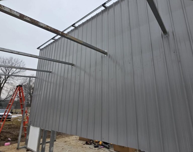 Steel wall panels being installed on a building frame